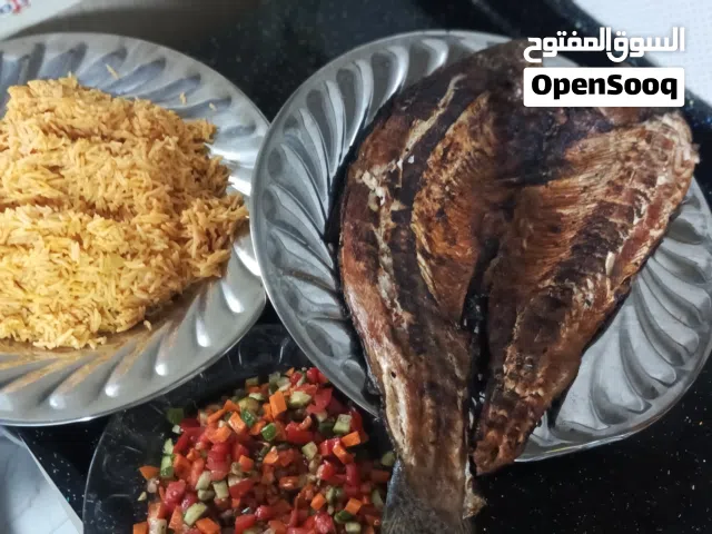 سمك مشوي على الفحم مع تمن احمر مع طرشي وخبز ولبن وبصل وليمون