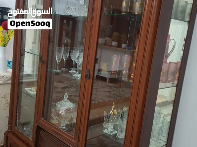طاولة مدورة حجم كبير وبوفي تلات فرادي فيه قجورا تحت والبوفي الاخر فردة وحده فقط وفيه قجر من تحت ل