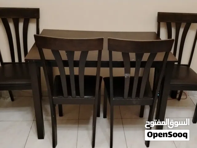 طاولة خشب مع أربع كراسي جلد