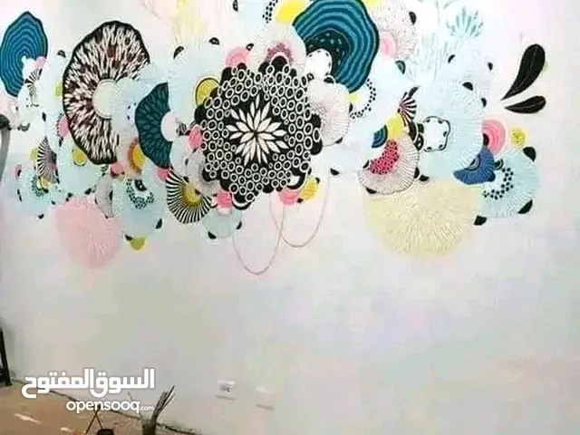 رسام وخطاط علي الجدران
