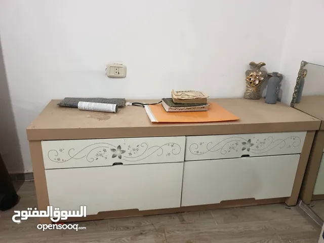 طاولة تلفاز بيضاء بيها دراج حجمها متوسط نظيفة