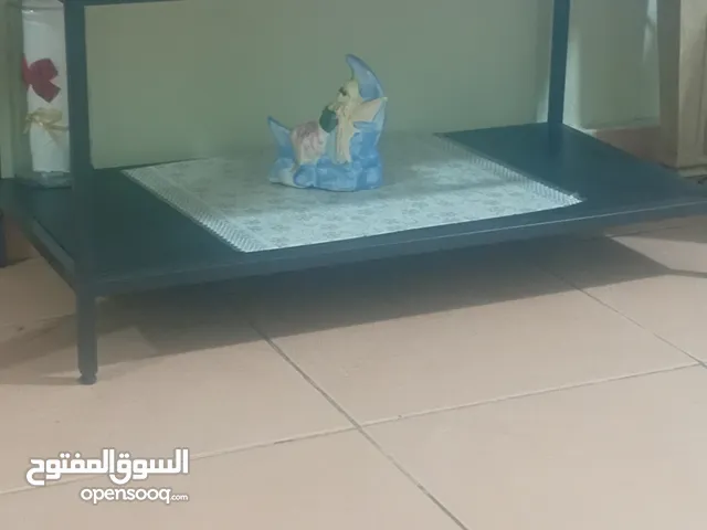 طاوله سوداء تحفه كبيره مساحه متوسطه اللون اسود و هي من فوق قزاز و من تحت شبه خشب و هي من ايكيا و تحف