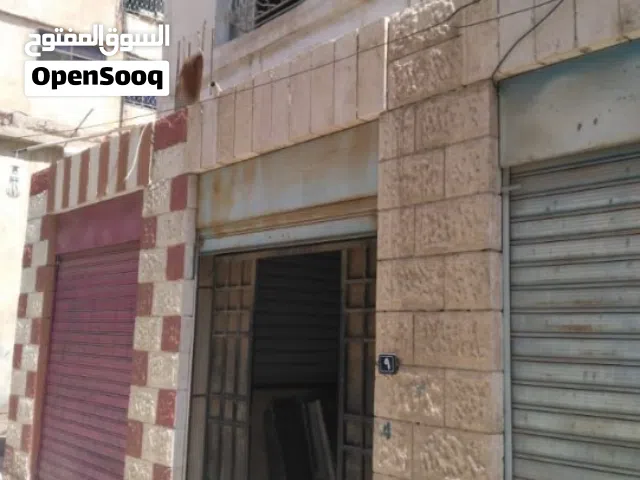 فرصة استثمارية في الزرقاء: أرض + 4 مخازن و3 شقق مجاناً!
