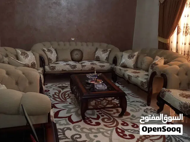 طقم كنب لون بيج مع بردايه وطاوله وسط واثنتين جانبيات