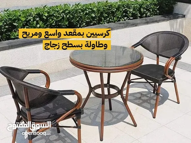 كرسيين  وطاولة سطحها زجاج للجلسات الخارجية للكافيهات والحدائق