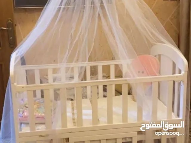 سرير اطفال خشب هزاز مع عجلات بلون الابيض