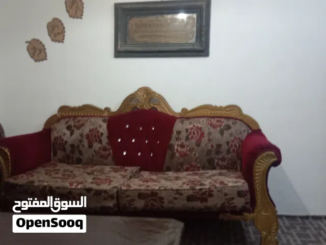 طقم كنب باللون الاحمر مع طاولات اثنين حجم صغير وواحده حجم كبير تفصيل قبل سنه استخدام شكل بسيط جدا