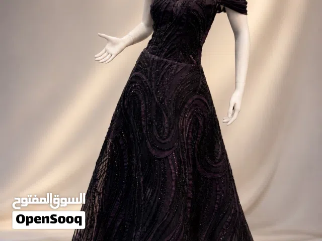 فستان ملكي بلون اسود مع تفاصيل بنفسجيه تعكس جمال الفستان