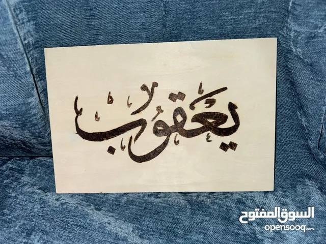 كتابة أسماء بتقنية الحرق على الخشب