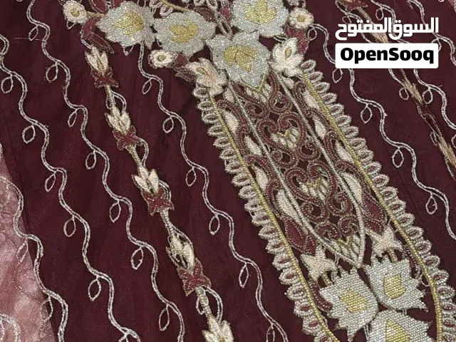 الثوب الإماراتي بلونه العنابي العميق