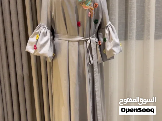 جلابية رمادية فيها تطريز على الصدر والاكمام