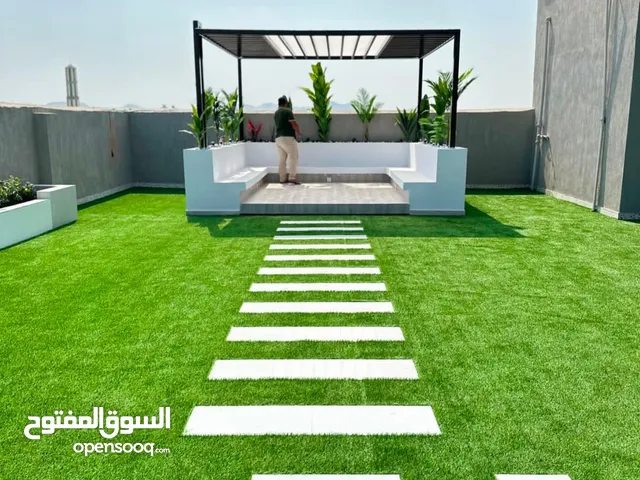 السجاد الاخضر الثيل الصناعي وديكورات بديل الخشب والإضاءة