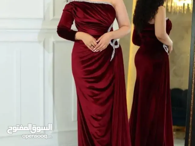فستان نسائي يتميز بتصميم فريد كم واحد طويل من الجانب الأيمن، بينما الجانب الأيسر مكشوف.