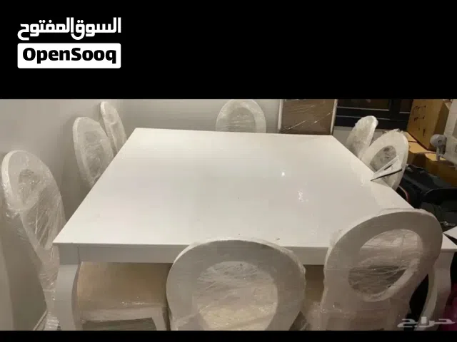 طاولة طعام بيضاء معها 8 كراسي