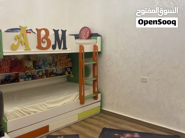 غرفة أطفال من ثلاثة أسرة بي فرشاتهم