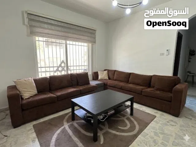 غرفة جلوس بلون بني مميز كنابيتين بحرف L مع سجادة و طاولة مميزة من IKEA