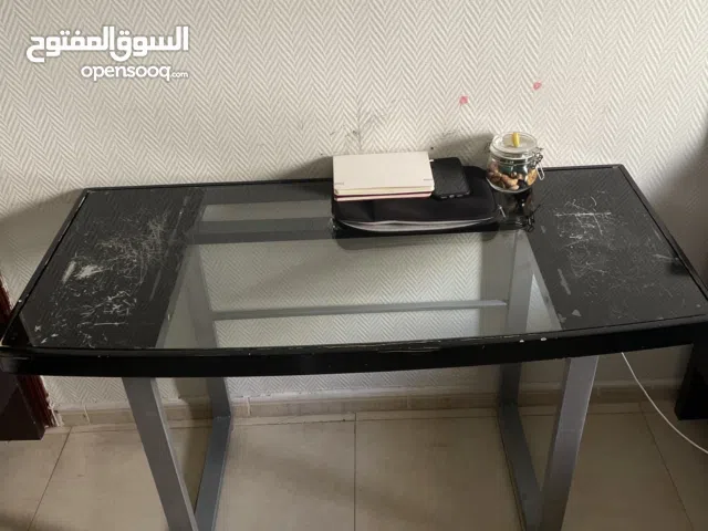 Black painted glass-top table with sturdy steel frame.