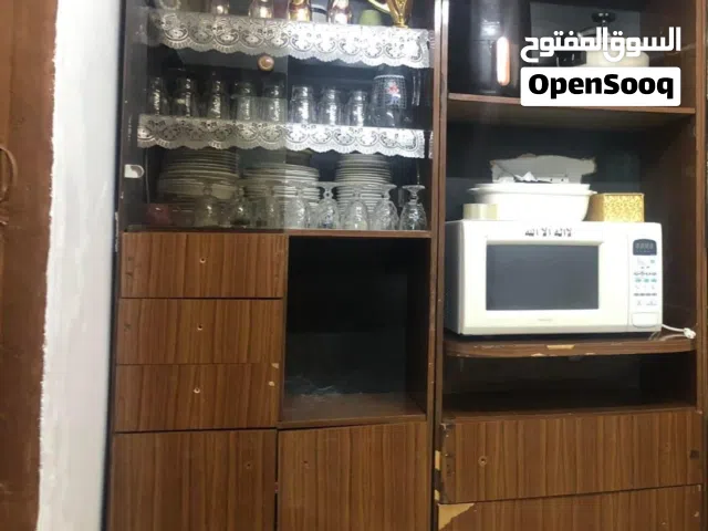 للبيع بوفيه مطبخ خشب مستعمل بحالة جيدة • مناسب للتخزين والتنظيم • فيه رفوف واسعة + جزيرة زجاج • يصلح