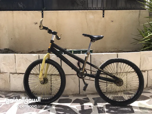 دراجة سوداء وذهبية بالكاد تستخدم في حالة جيدة جنت 20 نظيفة ومزينة بالملصقات Black and gold bicycle