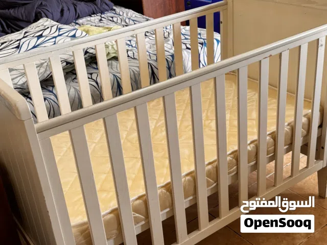 White wooden baby crib with matress