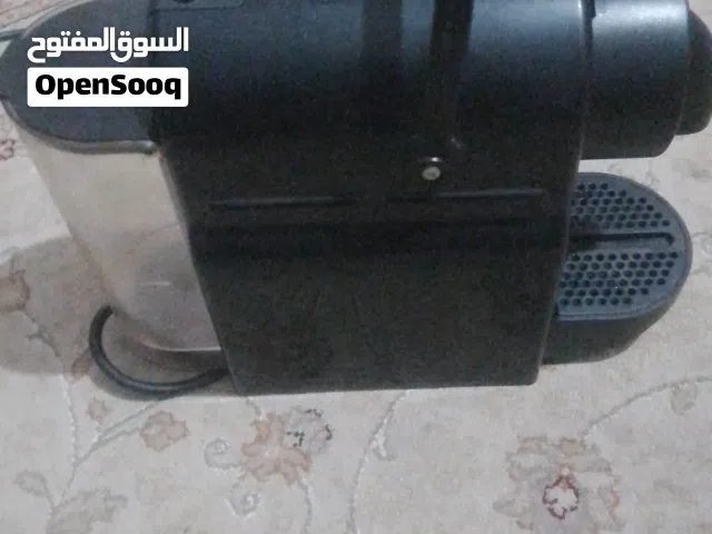 ماكينة Nespresso Inissia باللون الأسود ذات تصميم مدمج وخفيف الوزن، مثالية للمساحات الصغيرة.  تتميز ب