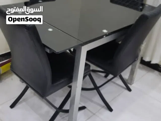 طاولة طعام زجاج ومعها 4 كراسي جلد