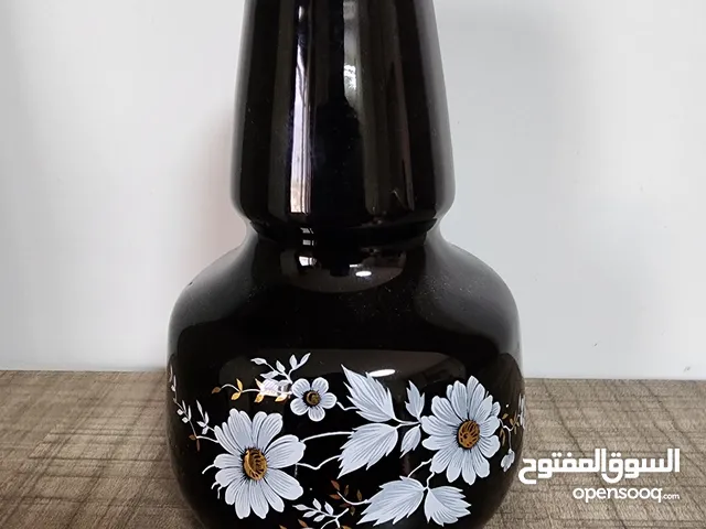 فازة مزهرية سوداء مزخرفة باللون الذهبي مع باقة ورد