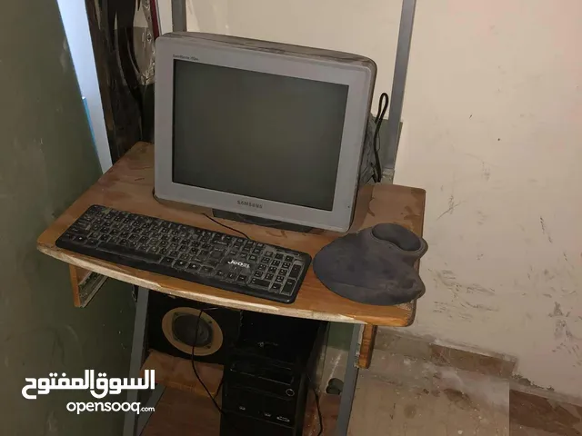 شاشة كمبيوتر وجهاز وكيبورد وسماعة وطاولة