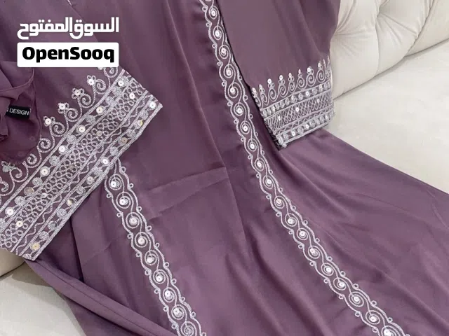 جلابية متروسة تطريز معاها شيلة وفيها لوقو البراند .