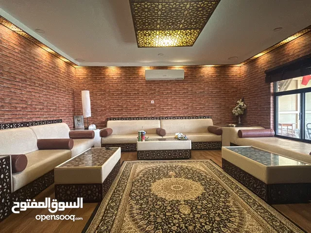 غرفة جلوس متكاملة السوفات والطاولات والسجاد وطاولة التلفاز وتصميم السقف