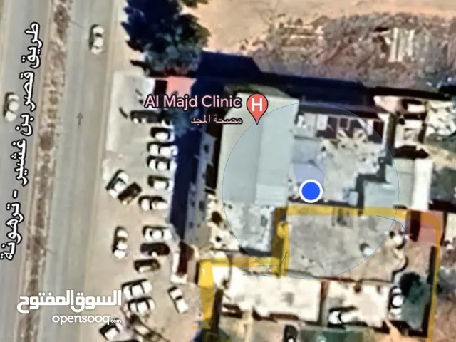 قطعة ارض على الطريق الرئيسي طريق ترهونة قصر بن غشير مساحتها 1106 متر مربع يوجد عليها عدد 2 منازل.