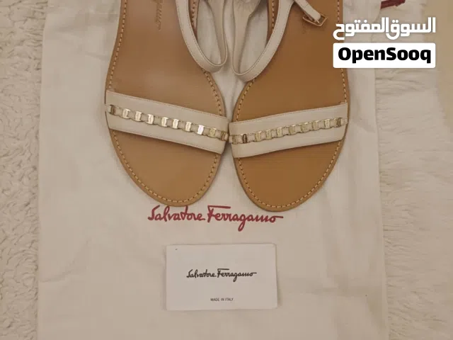 للبيع صندل نسائي فاخر من Salvatore Ferragamo باللون الأوف وايت مع تفاصيل معدنية أنيقه