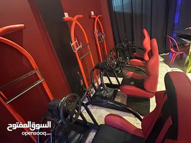 منصة سباق احترافية مع كرسي رياضي، ستيرينغ Logitech ودواسات Logitech، وهيكل معدني ثابت مع قاعدة شاشة.