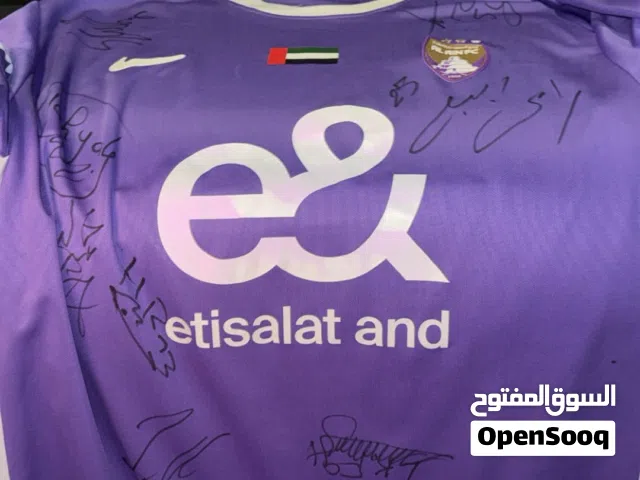 قميص موقع عليه من لعيبة العين والمدرب