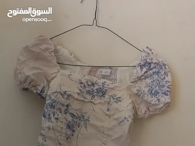 beige color shirt with blue flowers on it