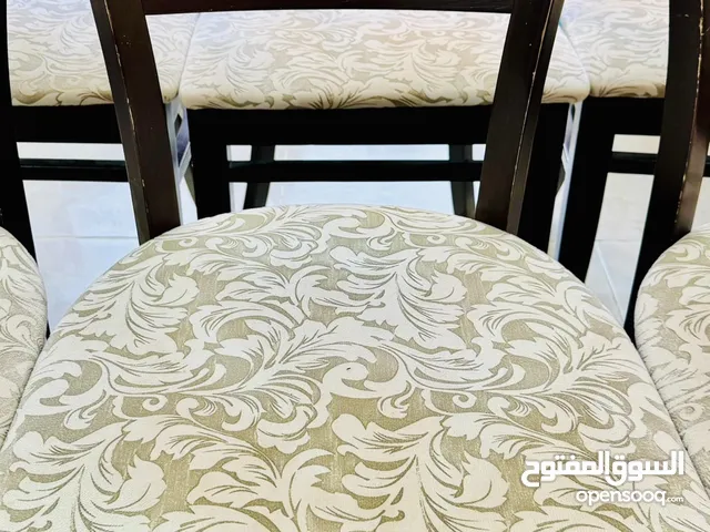 6 Wooden dining chairs with elegant floral-patterned upholstered seats.