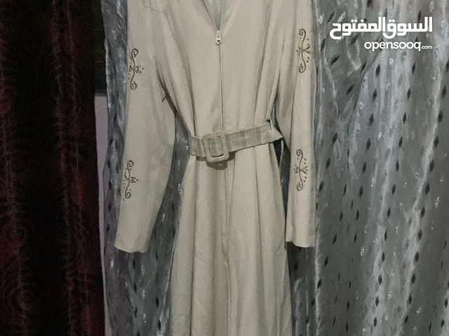 جاكيت طويل بلون البيج ويضاف عليه اشكال شجر بلون الاخضر