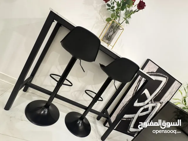 Two white tables and two black stools