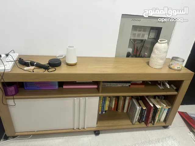 A fairly used tv stand with book shelves,