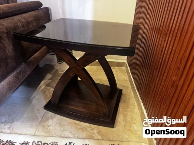 طاولة موديل Jocelyn، وهي طاولة قهوة (Coffee Table) خشبية تتميز بقاعدة هندسية على شكل حرف X وسطح مستط