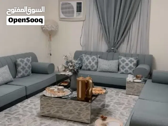 مجلس ارضي رمادي شامل الكنب والستارة والطاولات والنجفة
