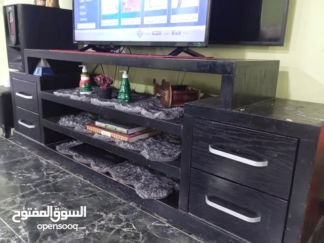 قاعد تلفزيون يحتوي على جرارات لون اسود