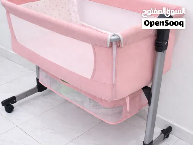 Pink baby basinet/ cosleeper with storage basket and bedsheet