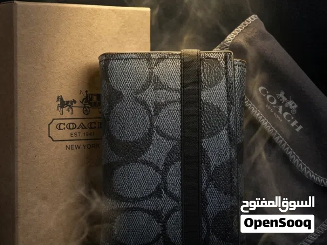 جيبك يستاهل الأفضل... من نيويورك لأيدينا — محفظة COACH الرجالية، الماركة اللي ما تحتاج تعريف.