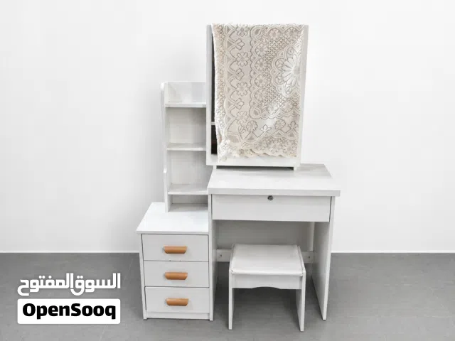 ميز ابيض خشب مع مراة ويحتوي على ثلاث مجرات صغار وواحدة كبيره مع كرسي صغير
