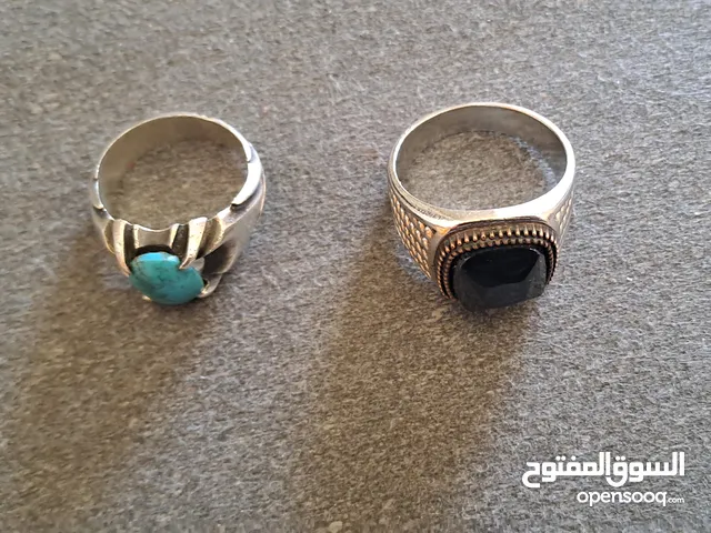 2 rings; 1st a silver ring with a turquoise gemstone,2nd with a black onyx stone.