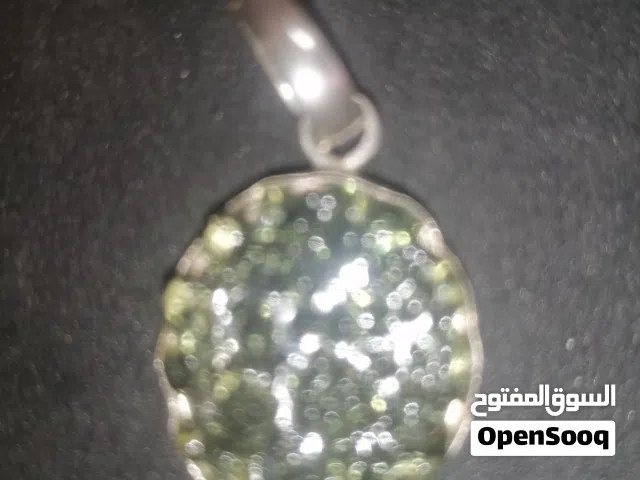 حجر المولدافيت الطبيعي، ويتميز بلونه الأخضر الزيتوني الشفاف وسطحه المتعرج