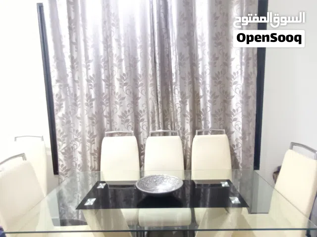 طقم سفرة هوم سنتر، طاولة طعام مع 6 كراسي جلد وبوفيه مع تحف وكرستالات أنيقة