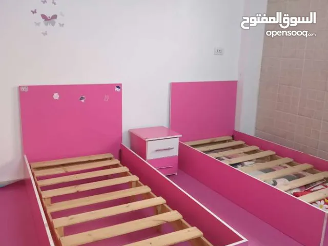 غرفة نوم مكونة من تختين وخزانة وكومادينا