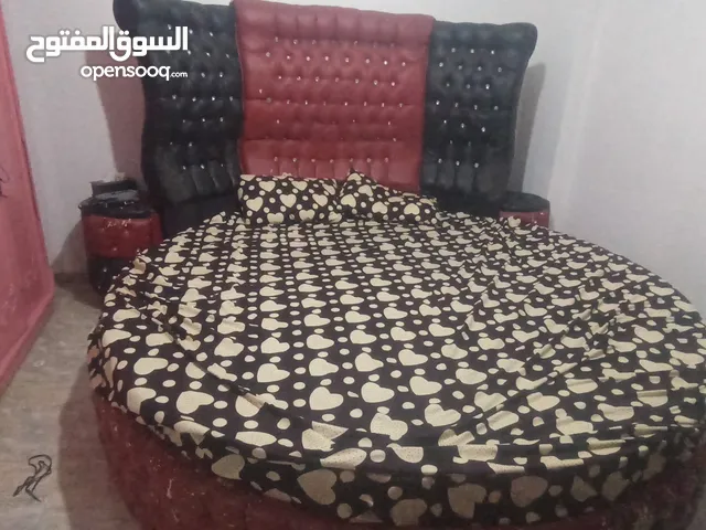 تخت دائري مع كومودينات وفرشه